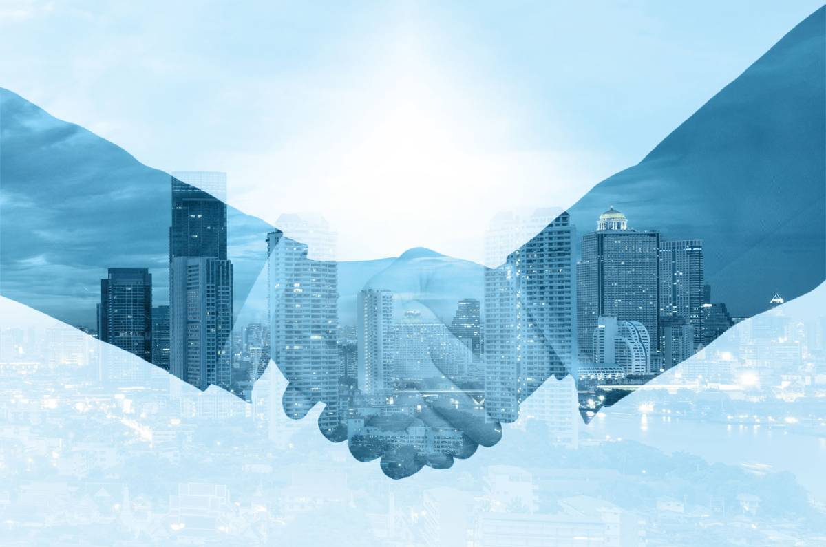 Businessmen shaking hands with city skyline in background
