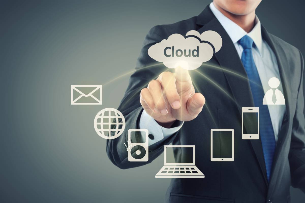 A man pointing to a cloud with phones, email, and computers connected to it
