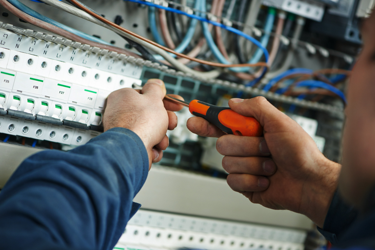 Close Up of Technician's Hands Using Screwdriver on Network Panel