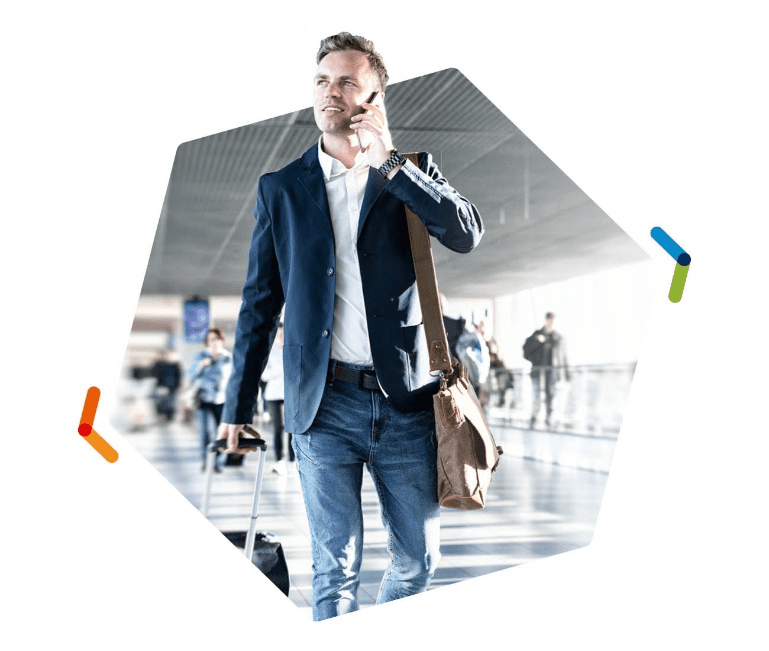 Man on cell phone walking through airport with brown bag over his shoulder
