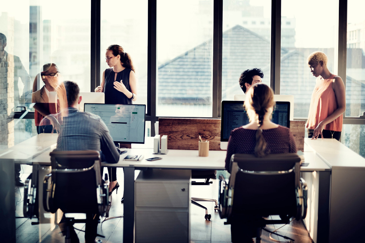 Business Team Sharing Desk Space in an Open and Modern Office Setting